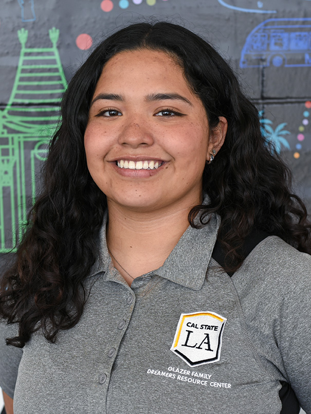 A person with long curly hair smiling.