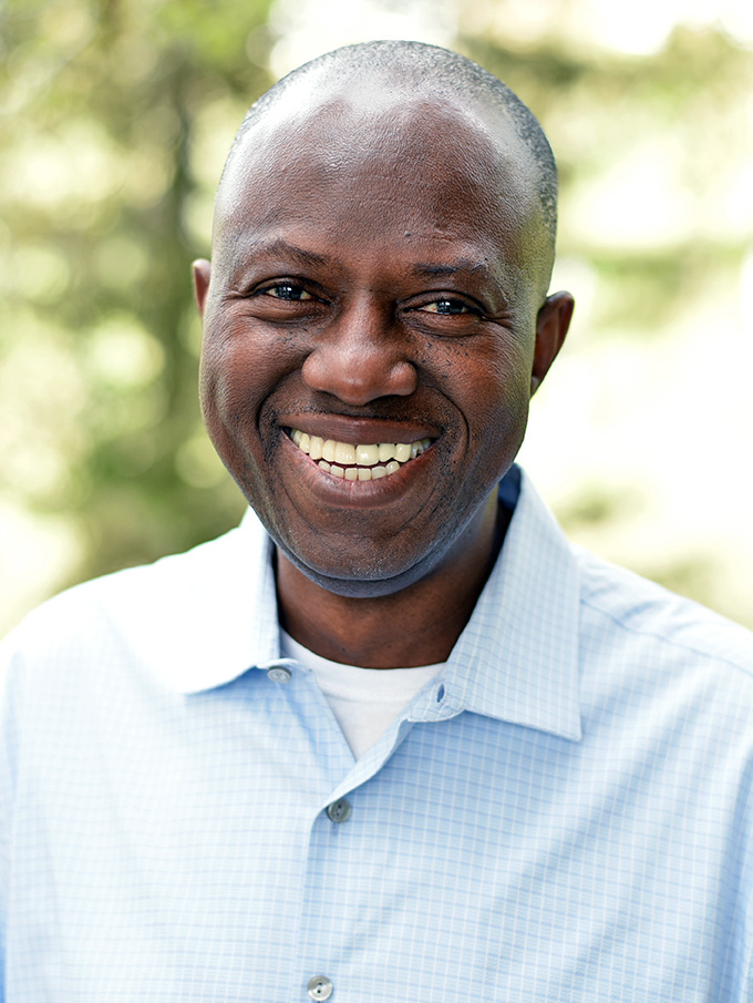 A person with short hair smiling.