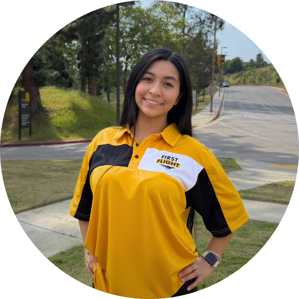 A woman smiling with black hair and a yellow polo.