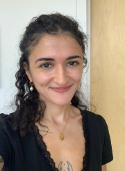 Manifa Baghomian wearing a black top in front of a white background