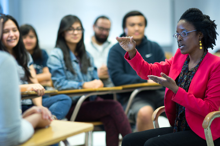 female advisor speaks to seated students in classroom