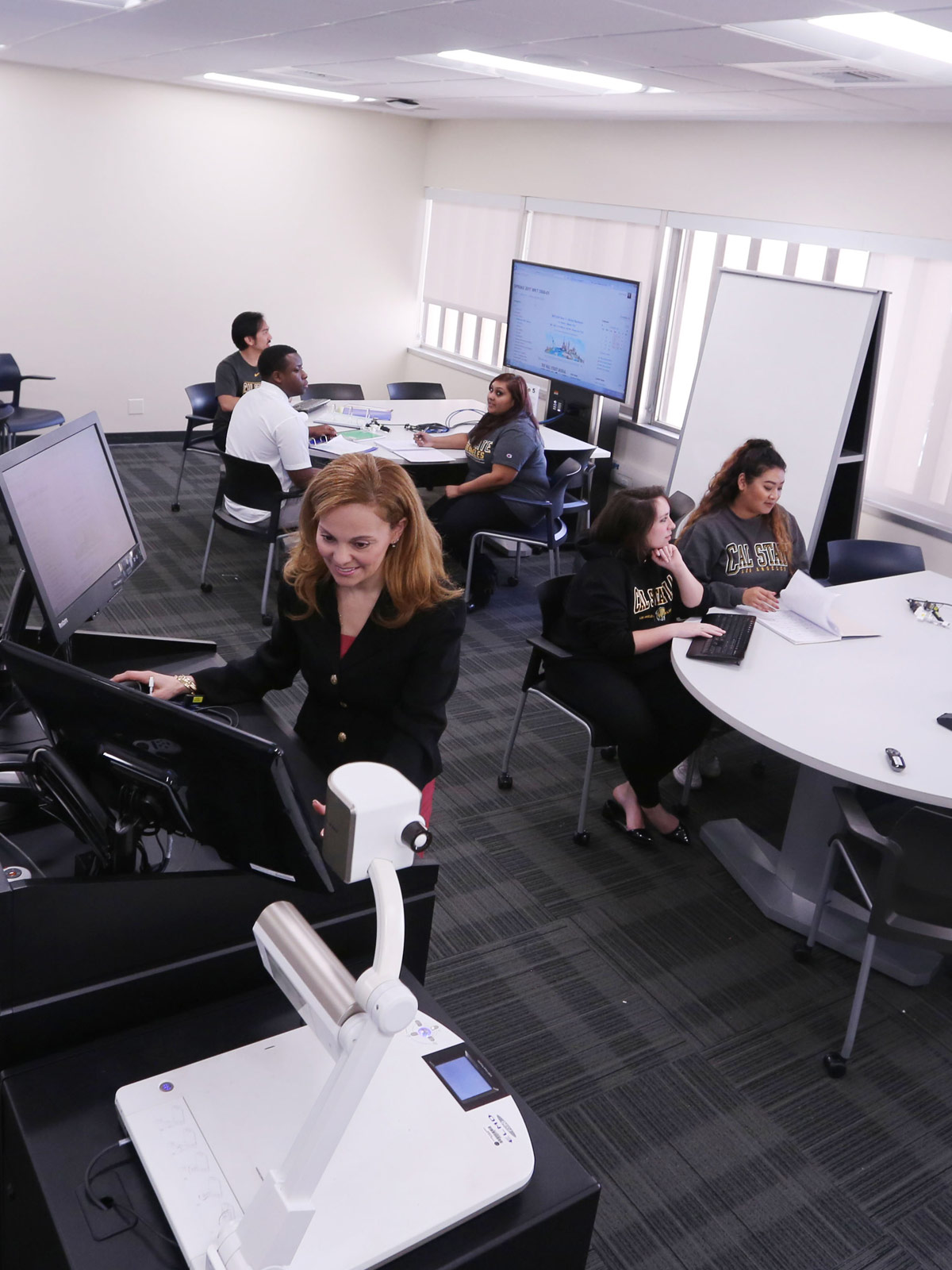 A professor uses a computer in a computer lab.