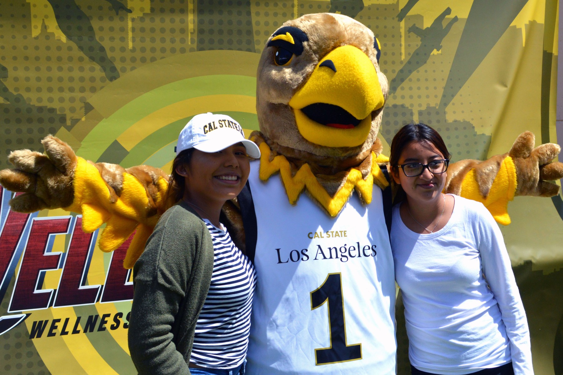 Eddie the Golden Eagle poses with two students.