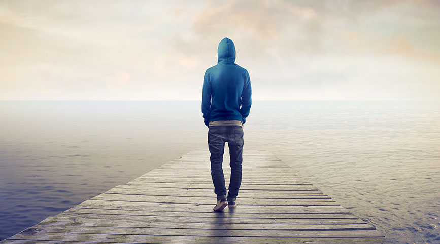 A lonely man stands on a bridge