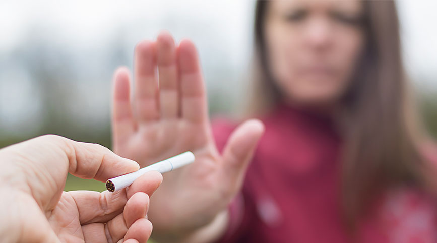 A female in the background rejects a cigarette.