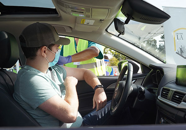 Person receiving vaccine at a drive thru at Cal State LA