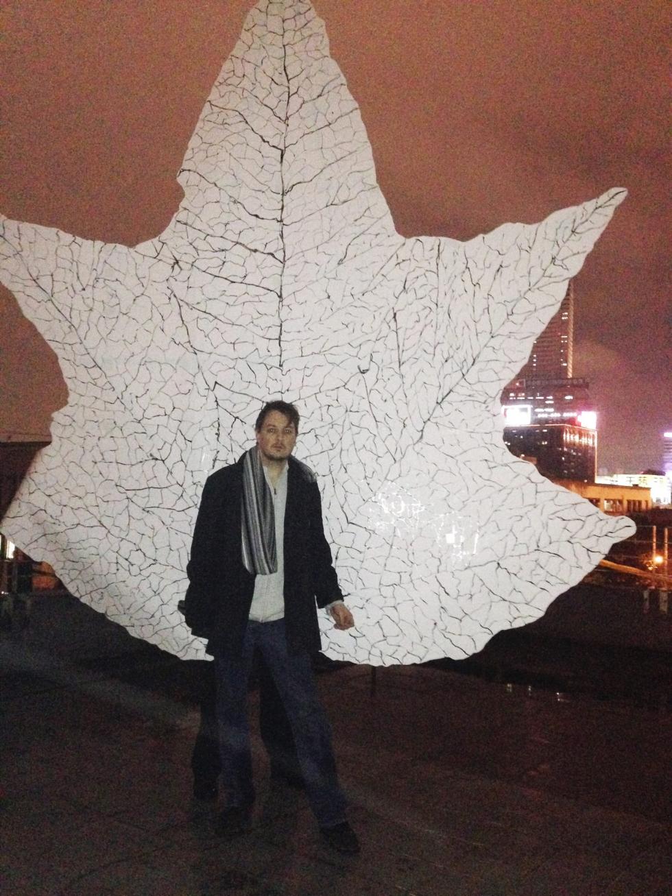 image os Jim Ovelmen standing in front of one of his paper leaf sculptures in Taipei