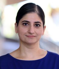 A female faculty headshot - black hair and brown top