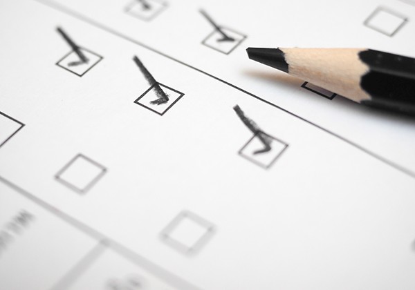 A close up of a check list and a pencil.