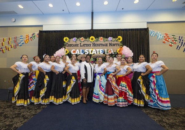 President and performers posing for photo at Chicanx Latinx University Alumni Network mixer