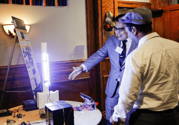 Two people smiling looking at an illuminated object