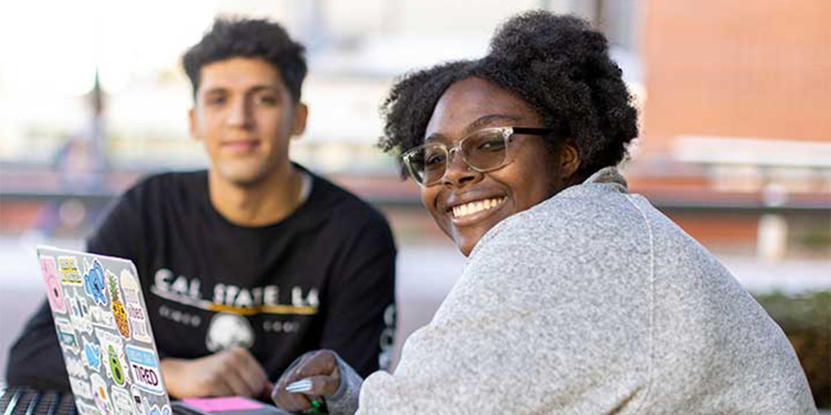 Two Students at table around computer