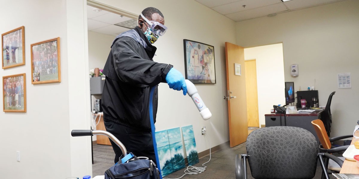 Staff disinfecting office surfaces