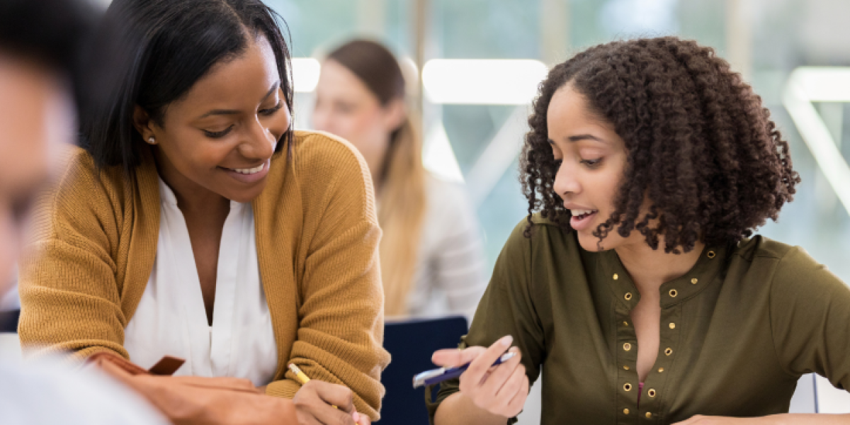 Female teacher and female student at desk.