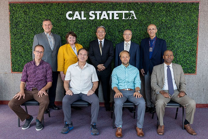 2022-2023 Outsnading Professor Award winners witting on chairs with the president and provost behind them