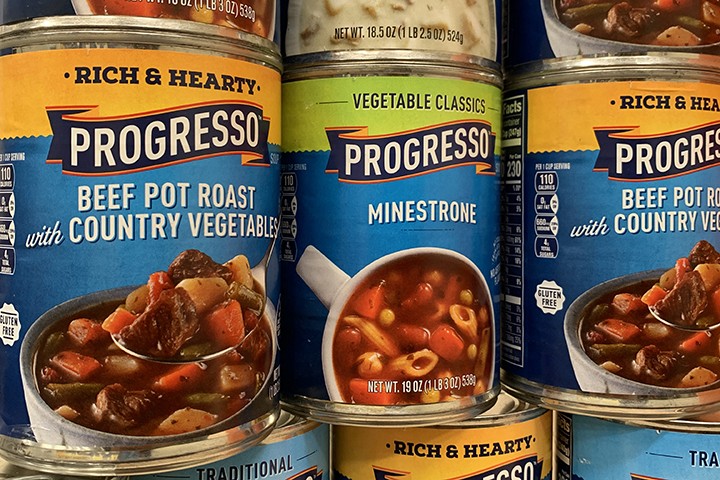 Close up of stacked cans of soup.