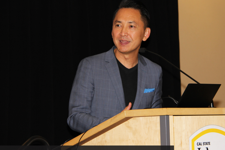 Man speaking behind a podium to an audience