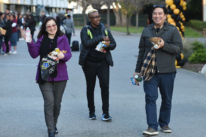 Three staff members walking down the main walkway.