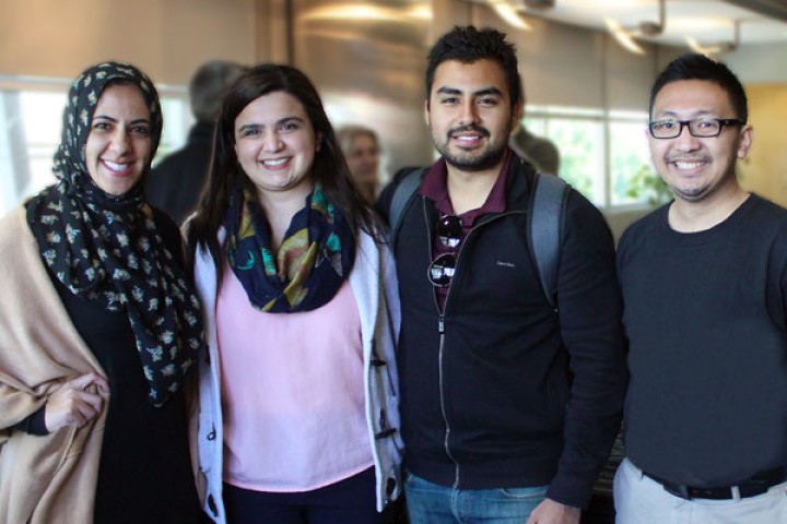 four students and graduates stand smiling