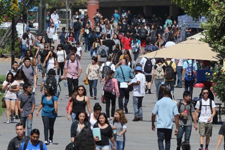 University Walkway showing the Library in the background. Students are walking aournd.