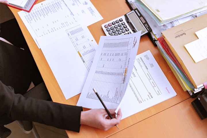 table covered with papers and calculator