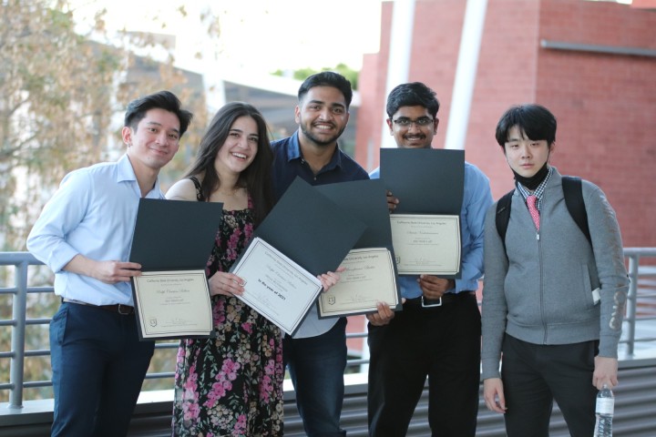 students holding certificates smile