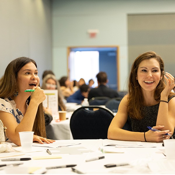 two professors sitting at a round table during a professional workshop