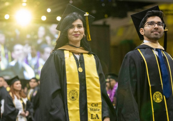 2 graduates at a graduation ceremony.