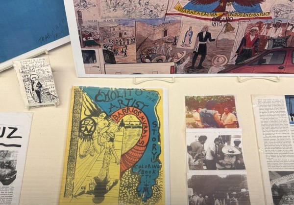 Archival materials, photographs, and artwork related to Chicano art and community history displayed in an exhibit case at Cal State LA.
