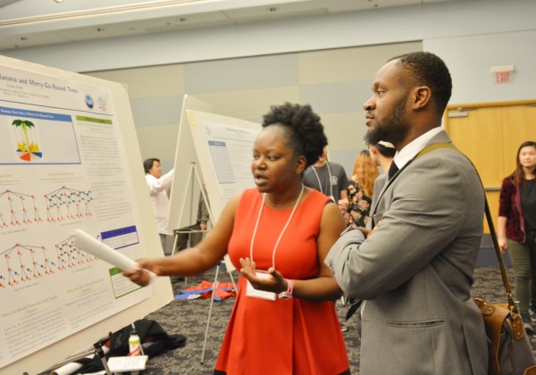 student discussing her poster presentation with attendee