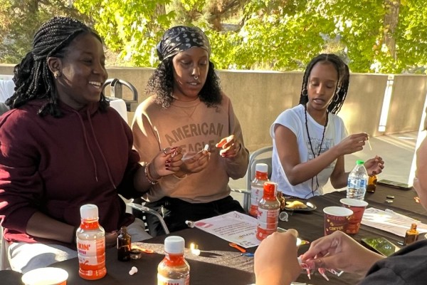 A group of students smiling and observing a spray bottle.