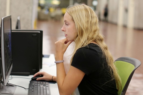 Image of female student in University Library using a computer station. 