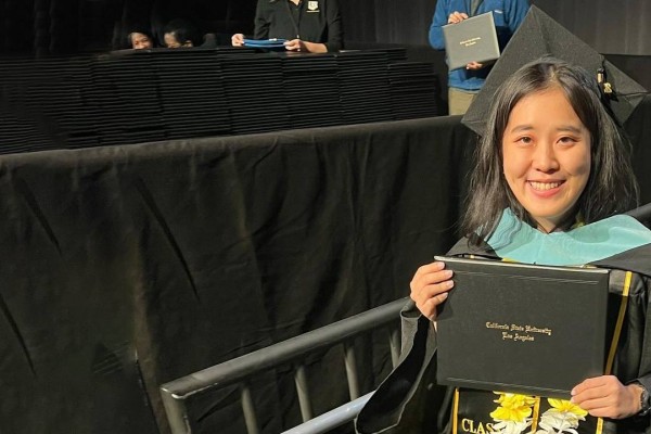 female graduate holding diploma