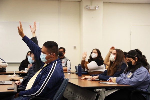 Students raising hands engaged at event