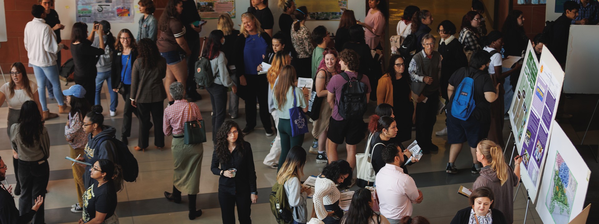 Large number of attendees looking at the different poster boards