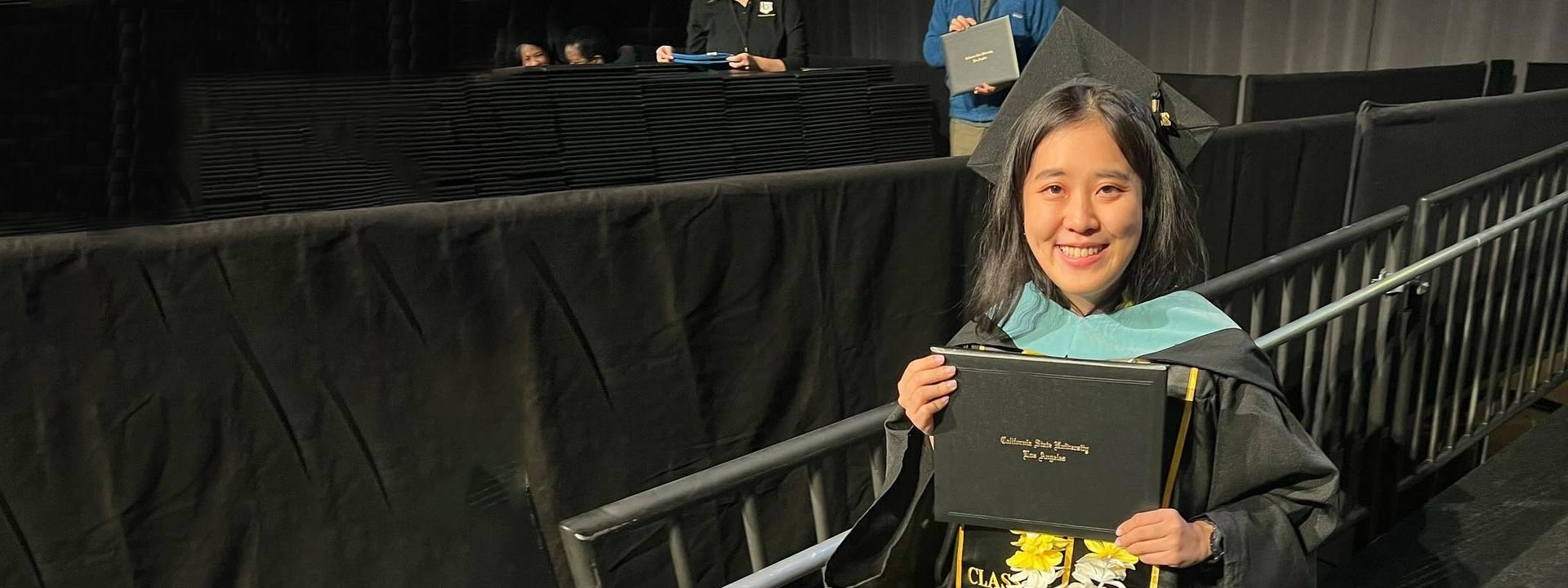 female graduate holding diploma