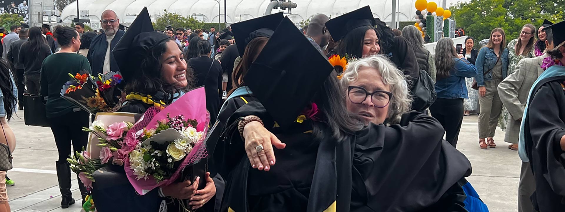 Lia hugging student graduates